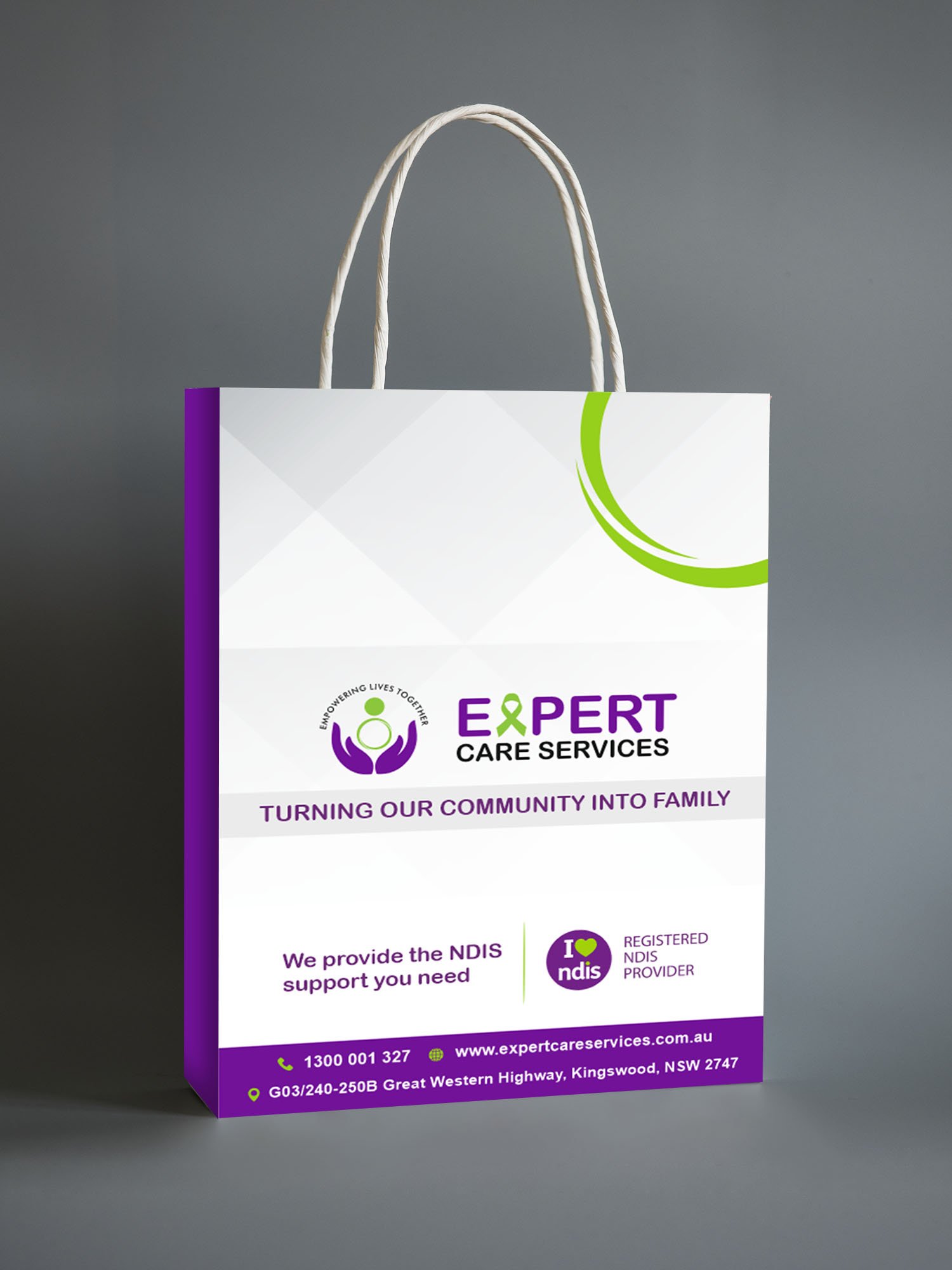 A white and purple paper bag with Expert Care Services logo and text, “Turning our community into family.” The bag displays NDIS branding and contact details at the bottom, including phone number and website.