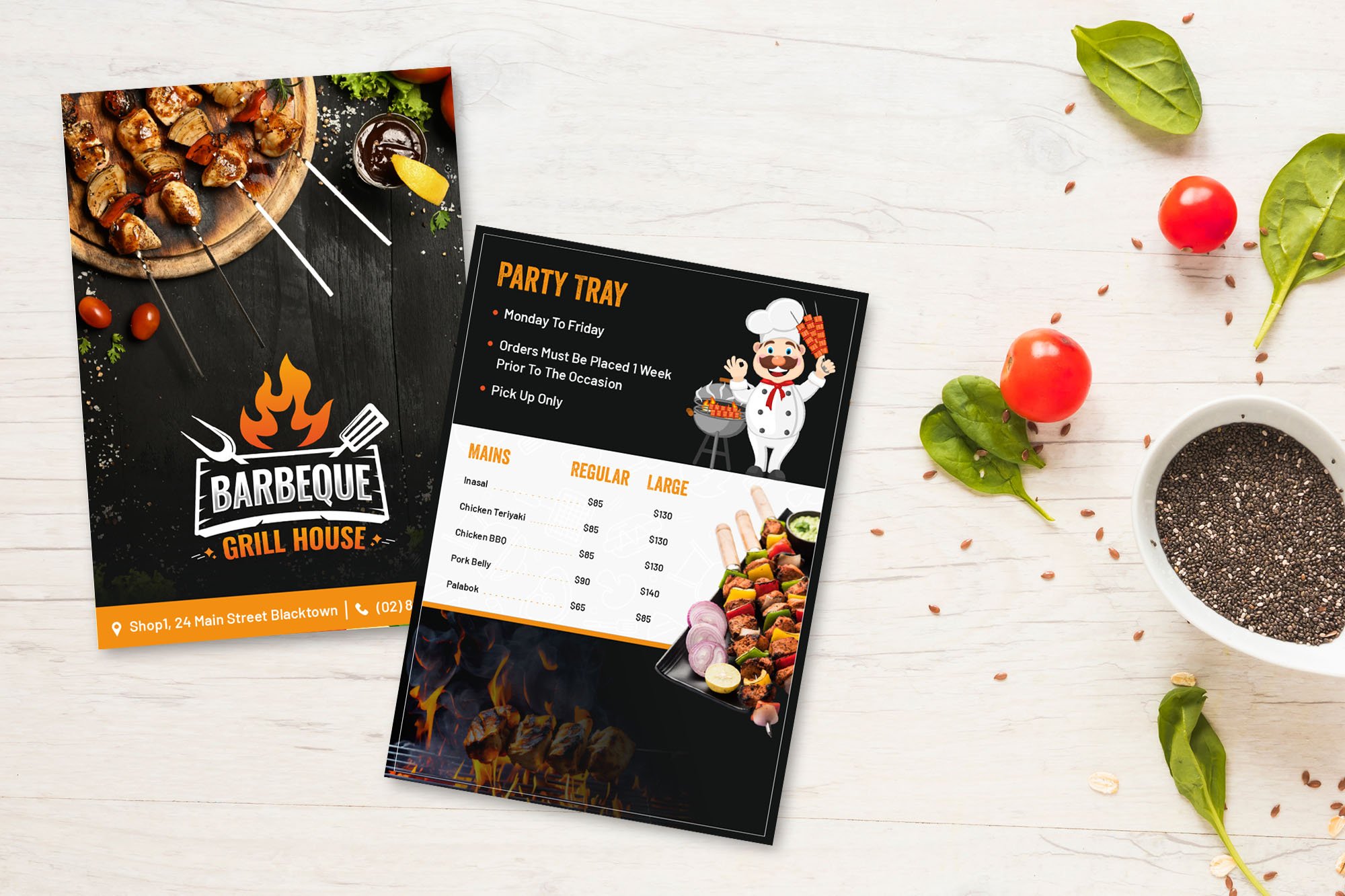 Two BBQ grill house flyers on a white table with basil leaves, chili, and chia seeds beside them. One flyer shows grilled meat skewers, while the other lists a party tray menu with illustrated chef and food images.