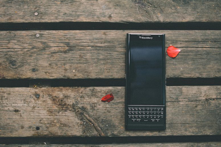 A phone of BlackBerry model lying on wooden table